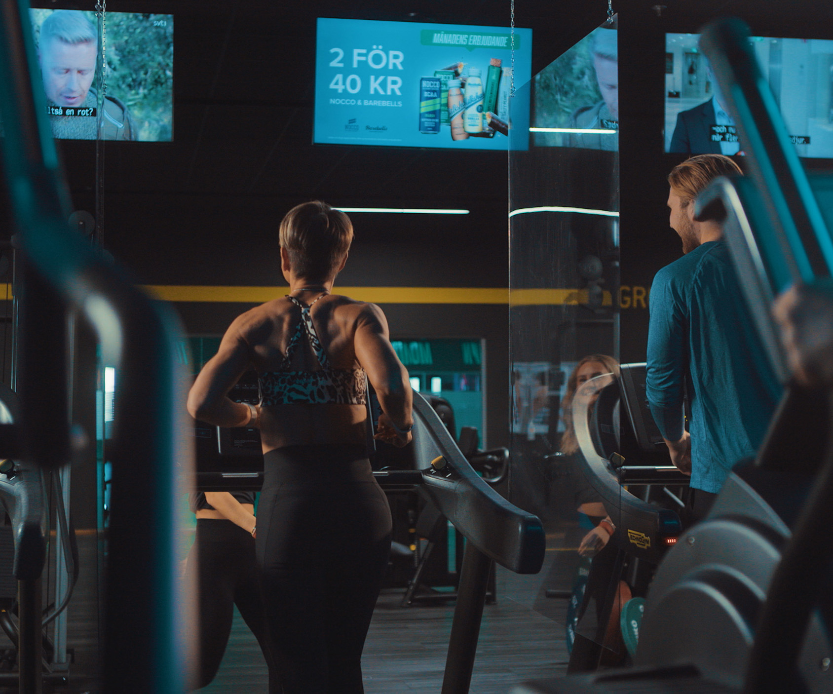 Kvinna Tränar På Ett Gym Med En Reklamskylt I Bakgrunden